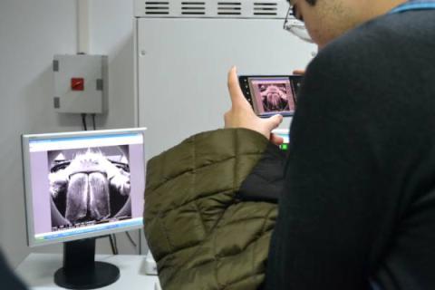 Detalle de un niño fotografiando una imagen de laboratorio